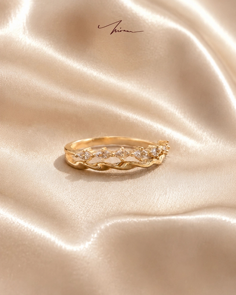 Cincin emas halus bergelombang bertatah berlian di atas sutra krem