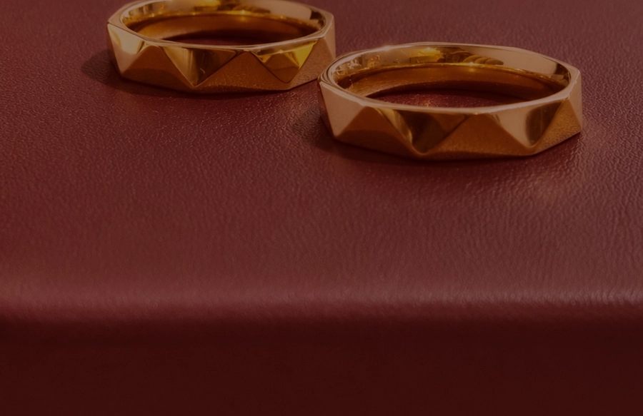 Sepasang cincin pernikahan emas di atas kulit mauve